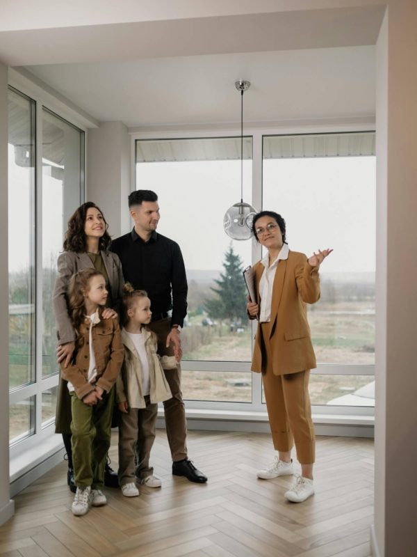 A realtor shows an open, airy room to a family